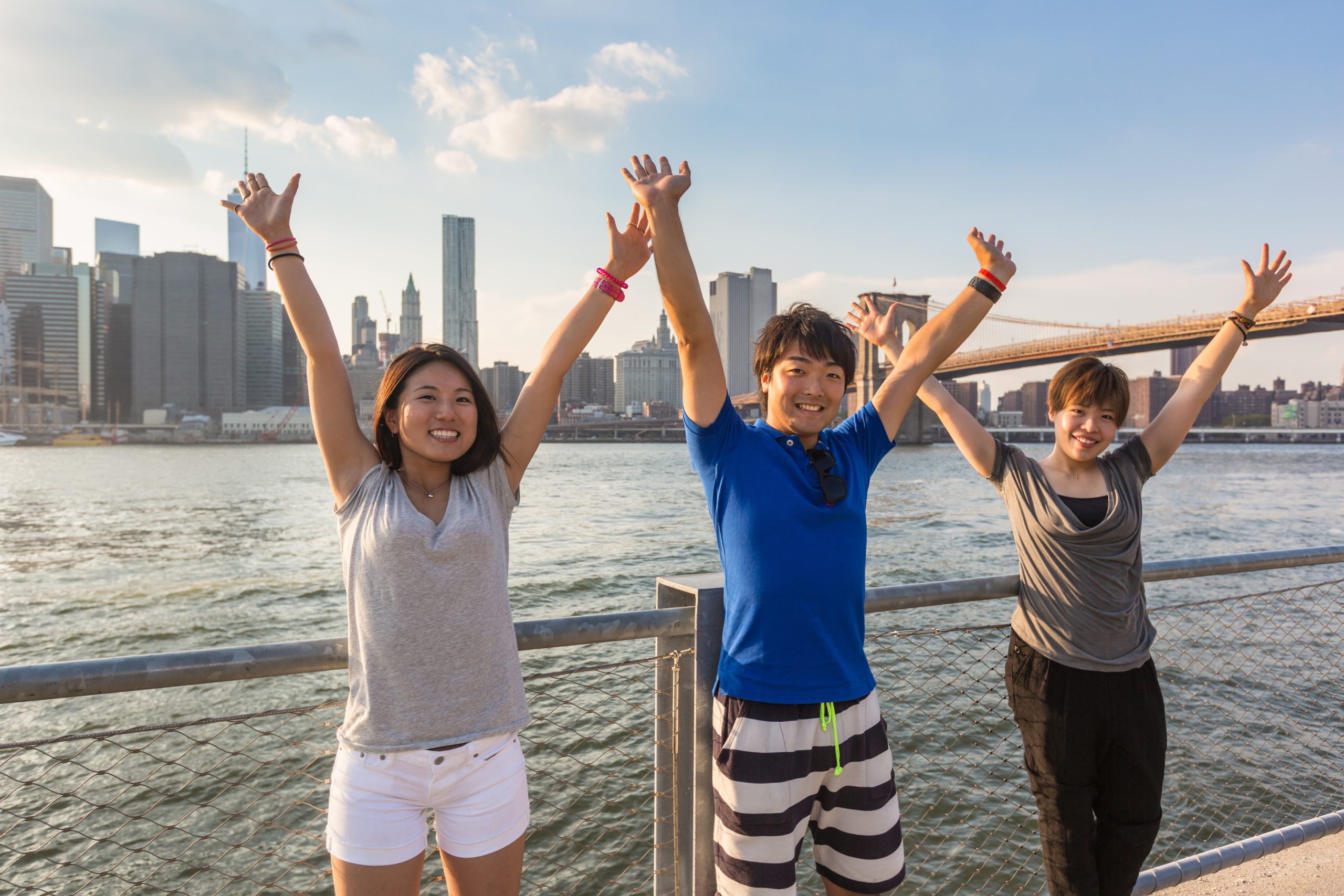 Students with hands in the air in front of the NYC skyline