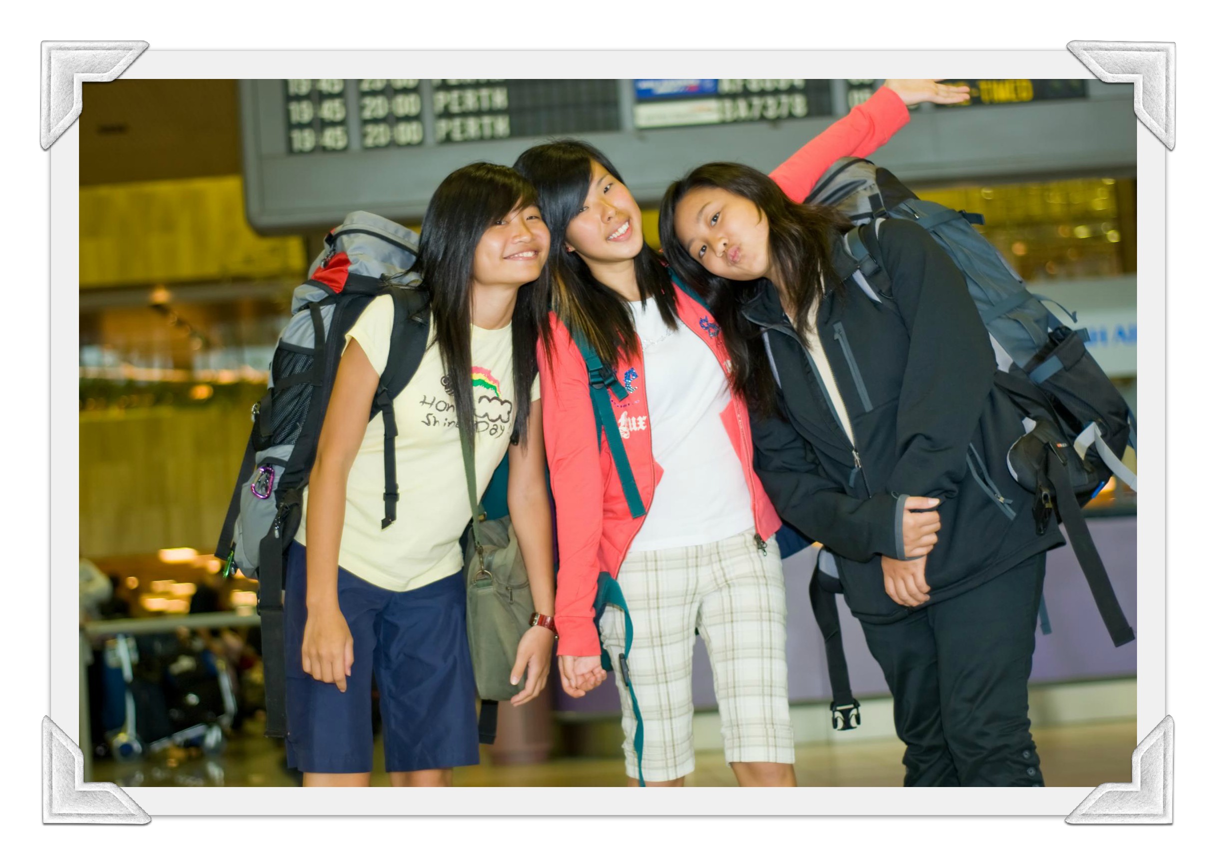 Three friends smiling together at the airport