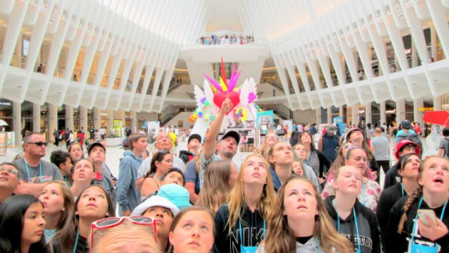 Students looking up at a ceiling inside a building