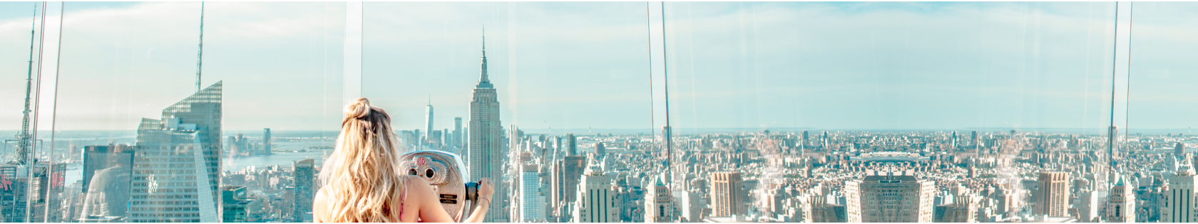 Student looking at the New York City skyline from a tall building