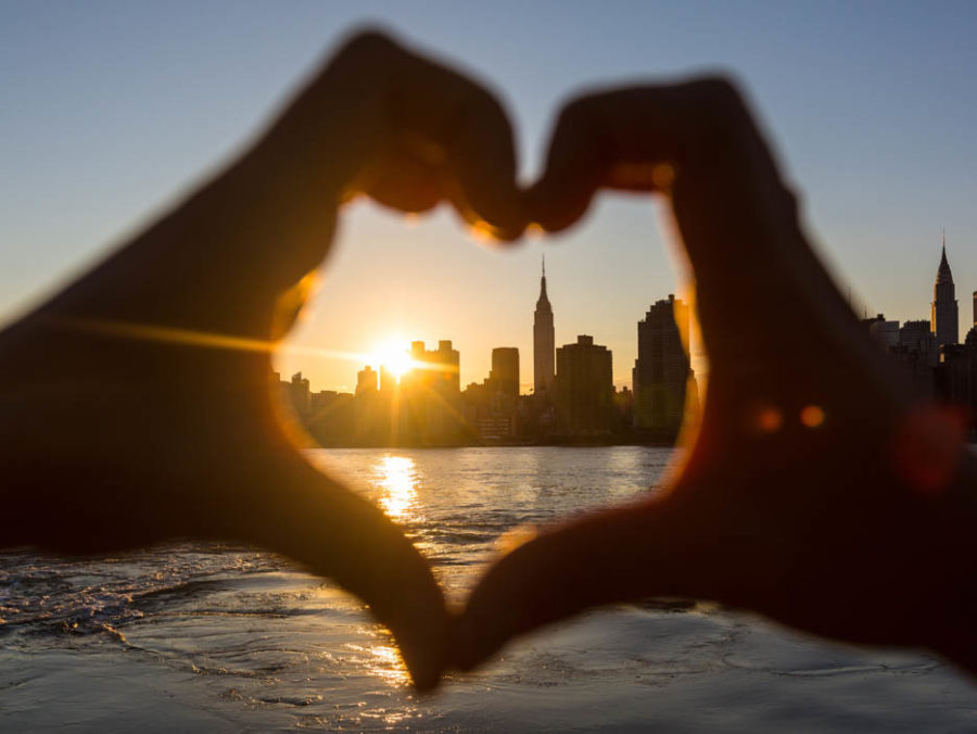 Hands making a heart with the NYC skyline in the middle