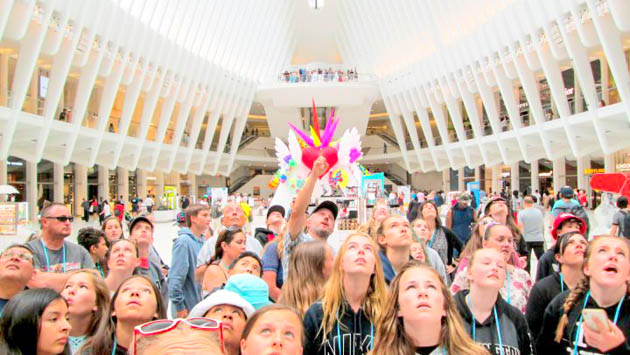 Group of students all staring up at a ceiling in a building