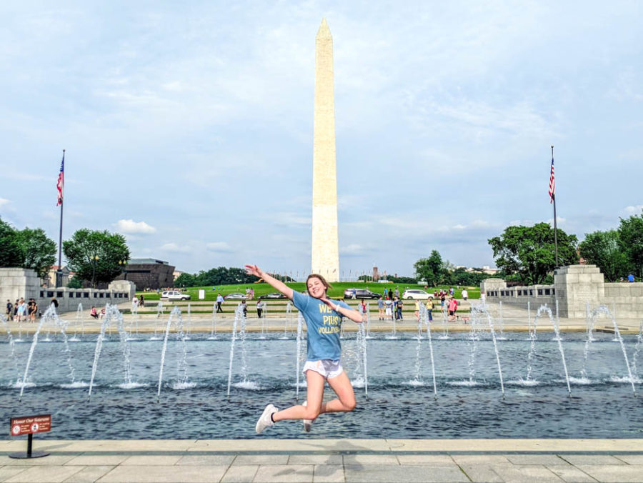 Teenage girl student jumping in the air in front of the reflecting pool in Washington, D.C.