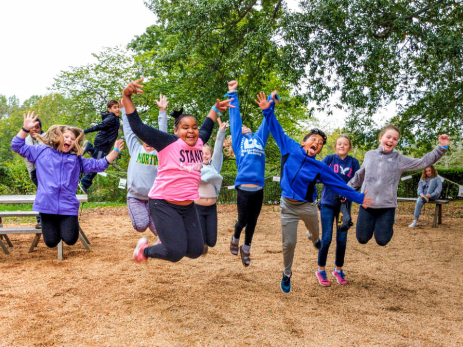 A group of young students all jumping in the air