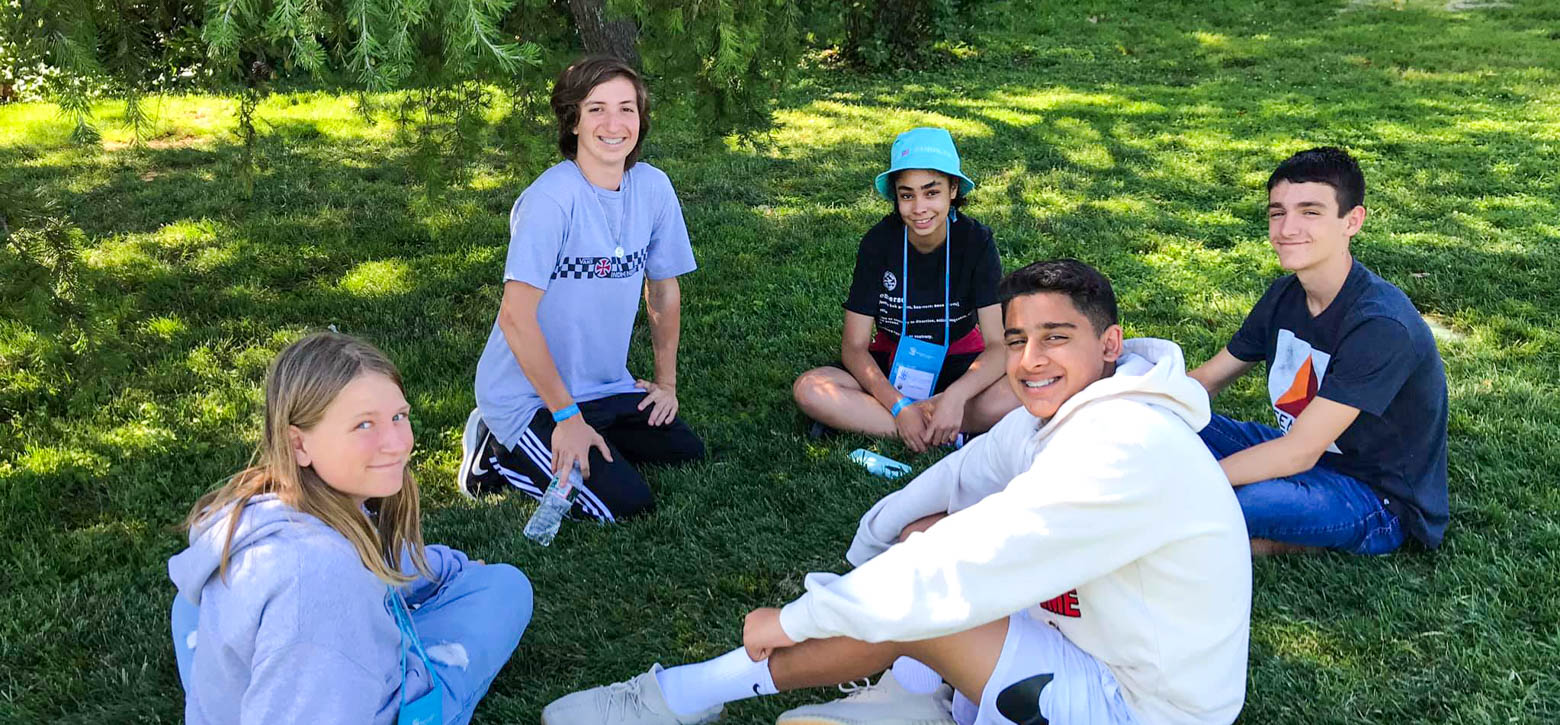 Students sitting in a grassy field