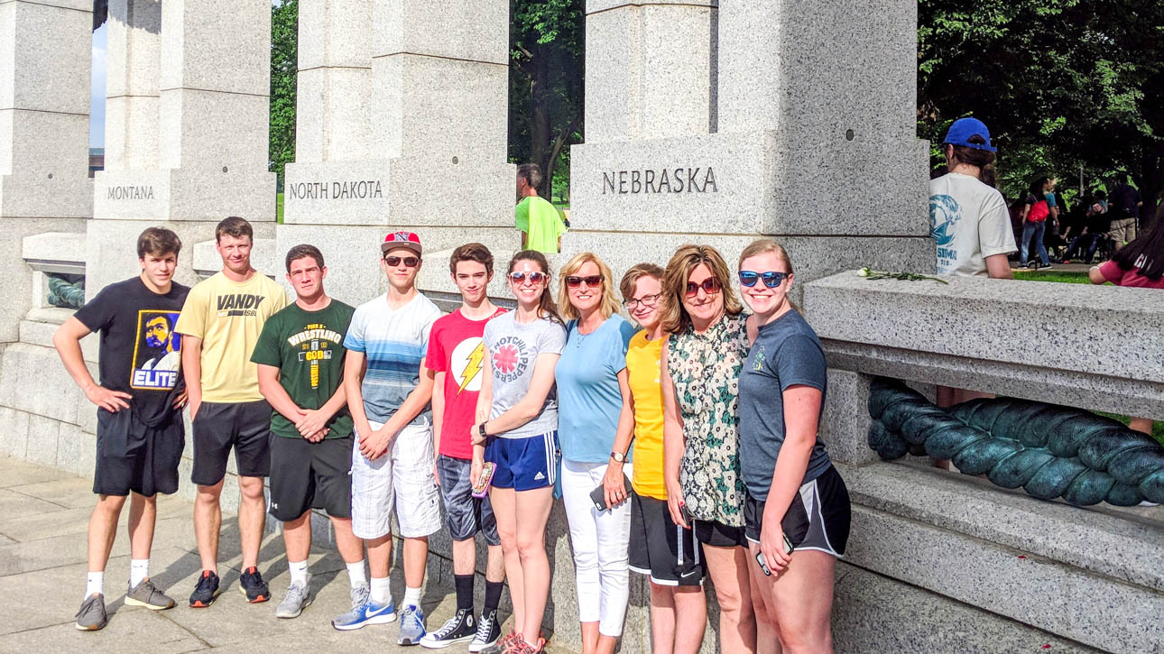 Group of students a teachers in front of a monument