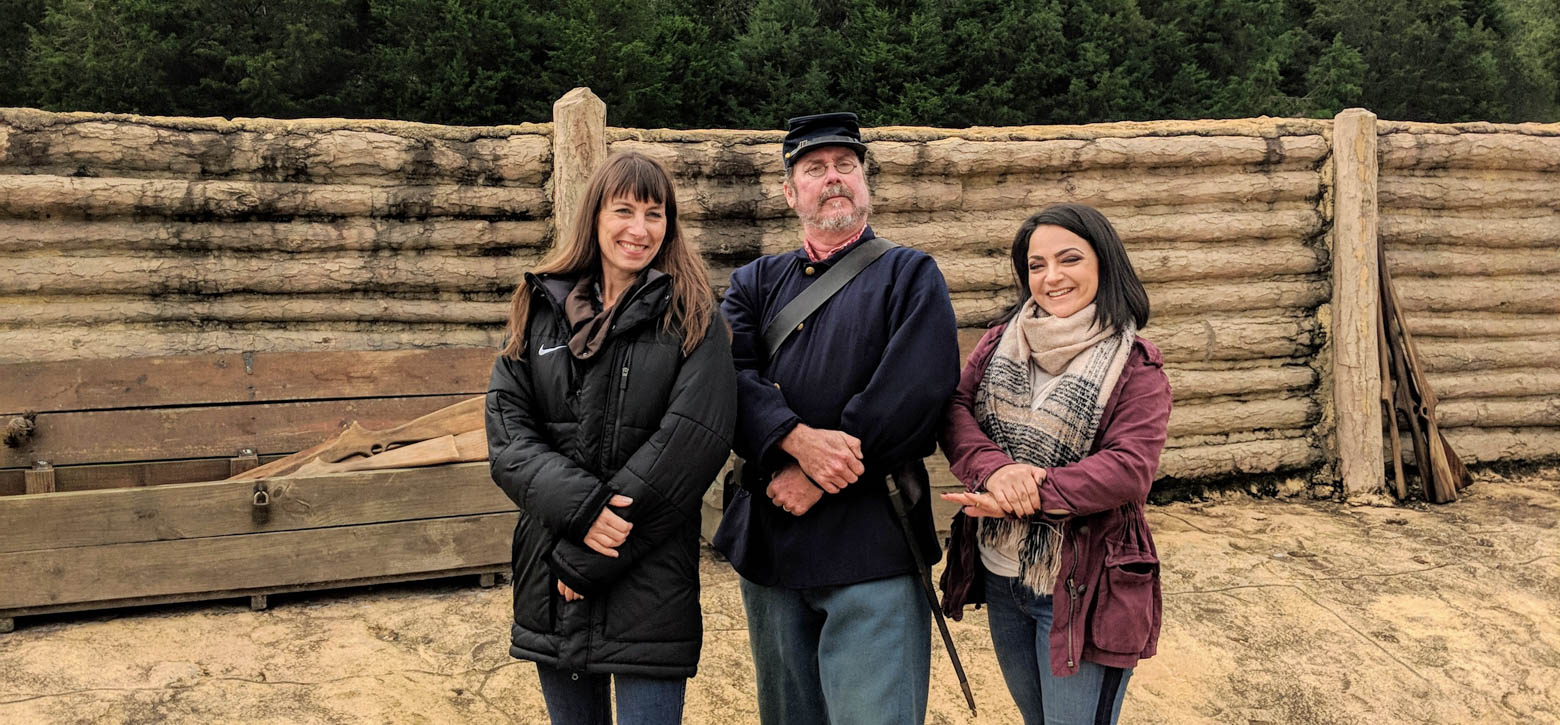 Two teachers posing with a reenactor