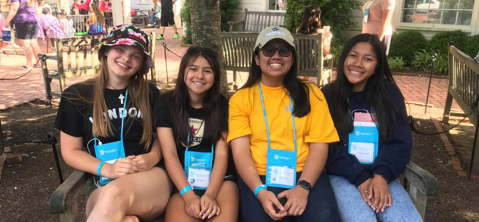 students smiling at the camera on a tour