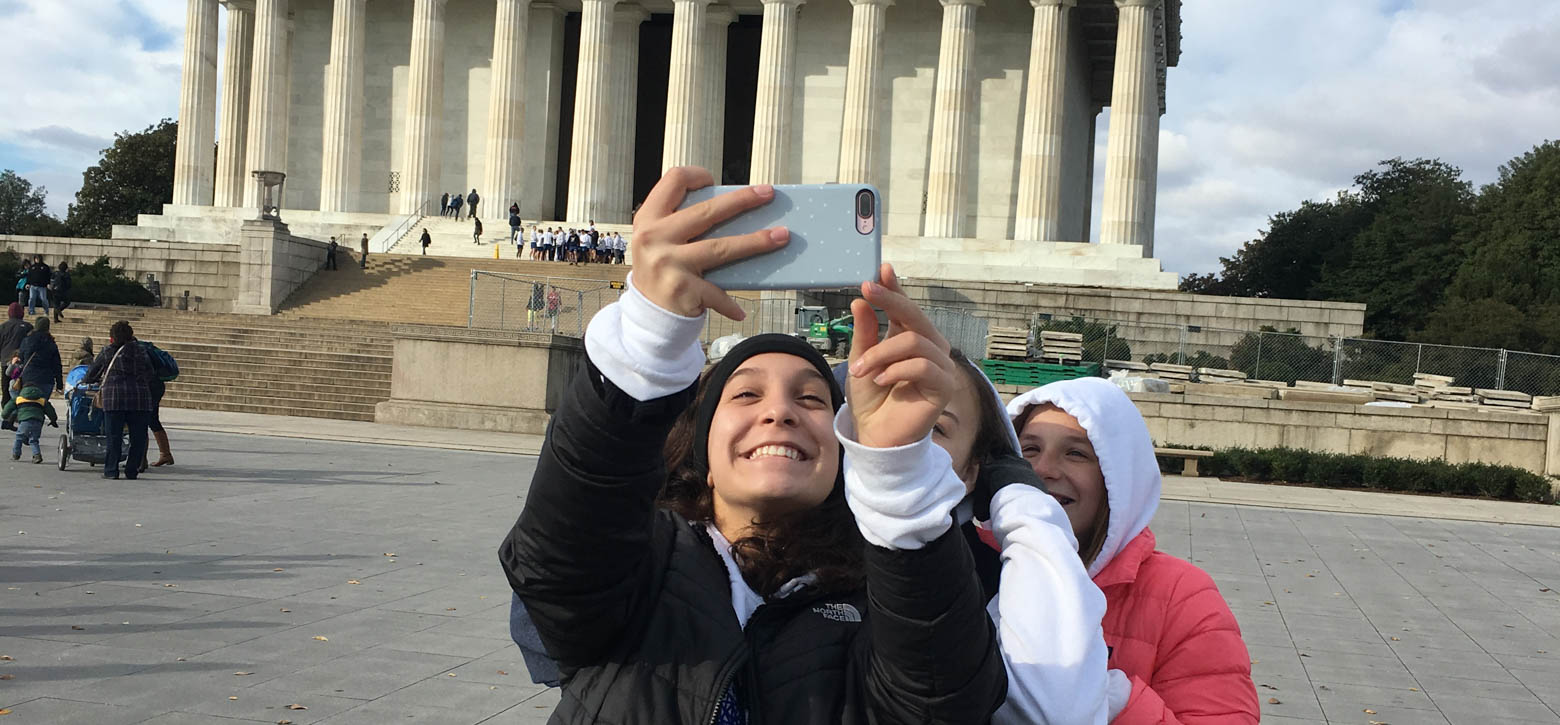 two young students posing in front of the Washington Memorial