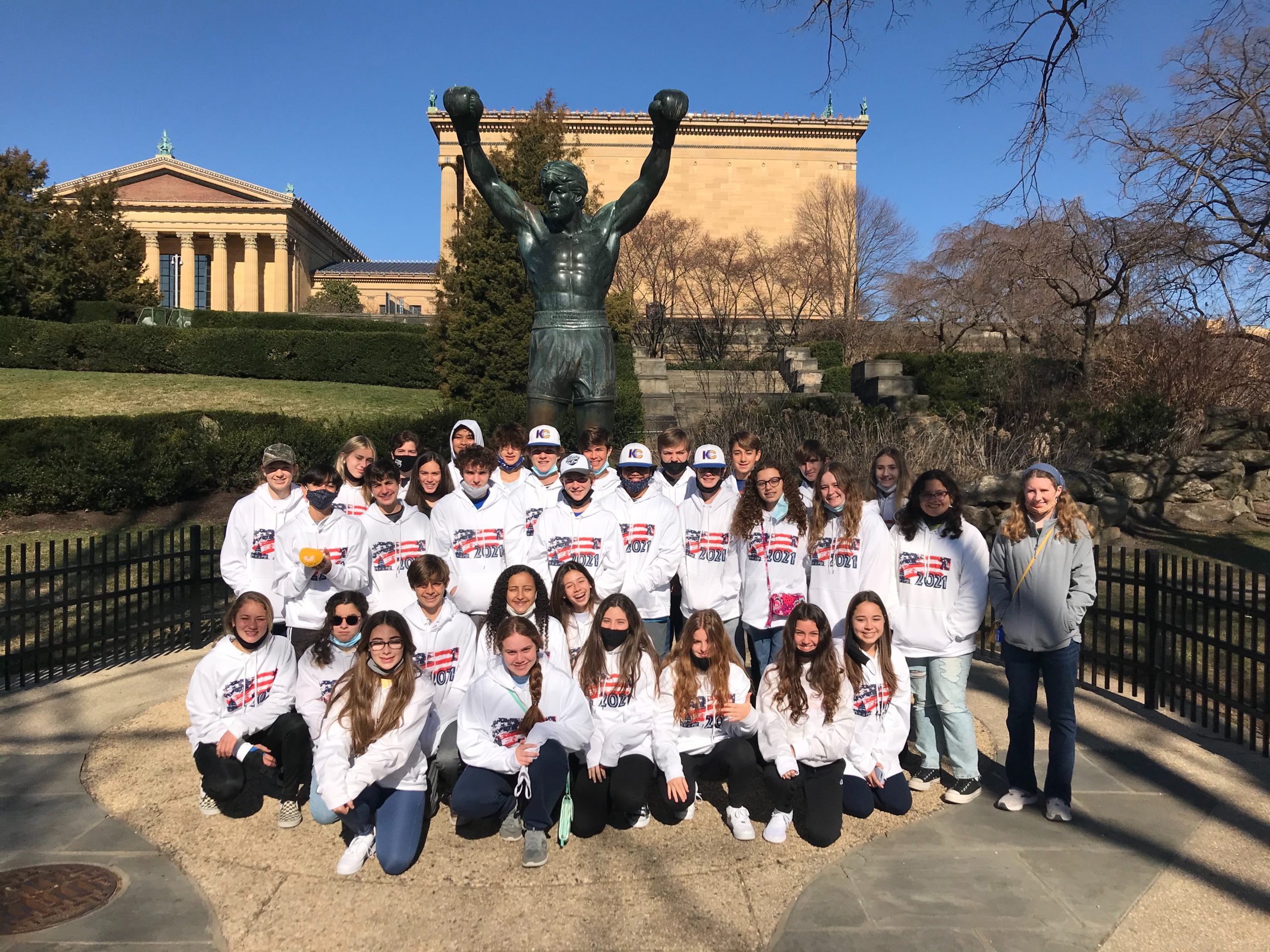 group of kids on a tour in front of the Rocky Balboa statue