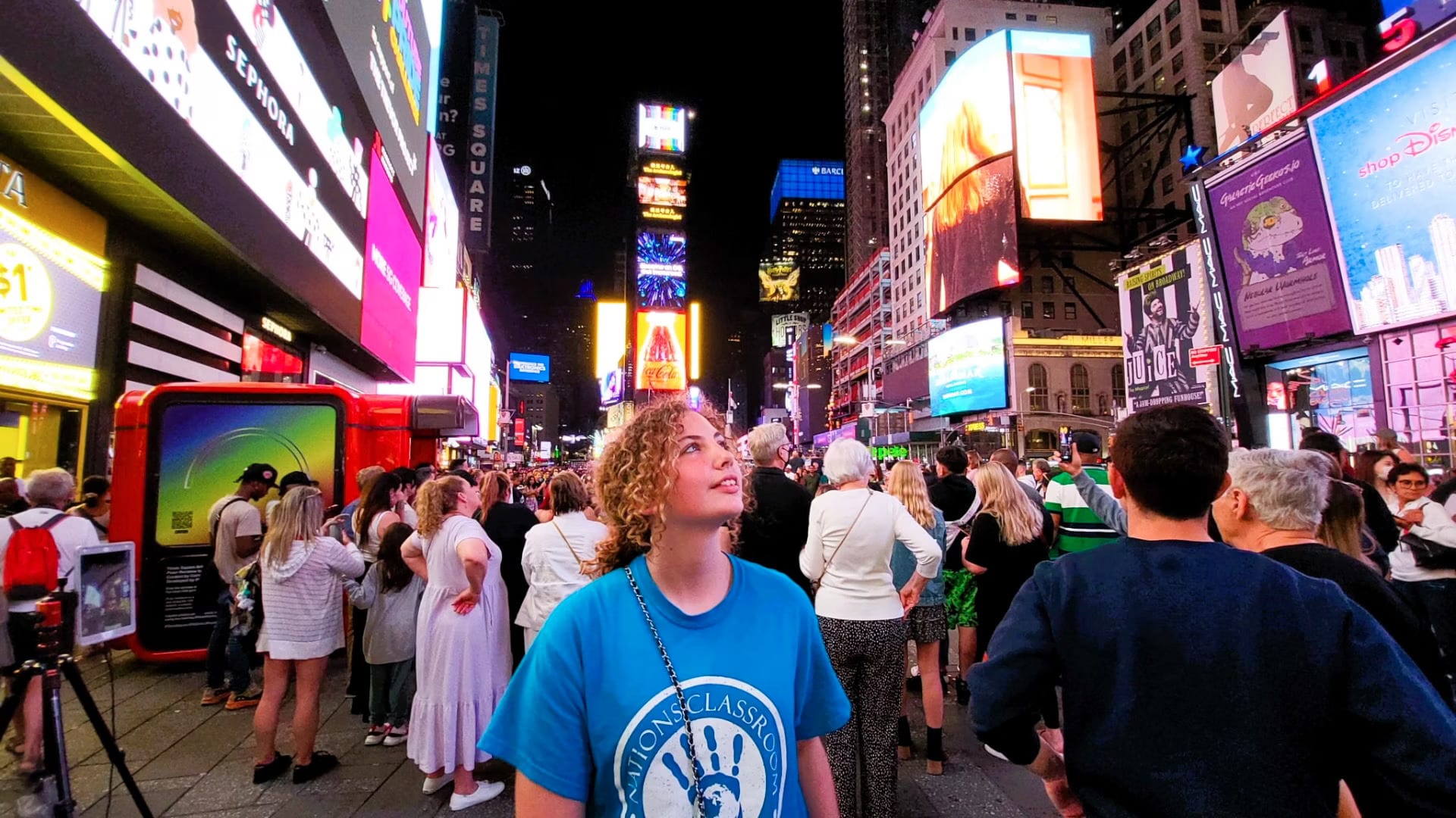 Young gurl staring at billboards in times square.